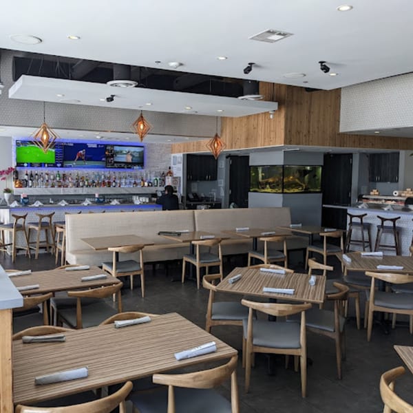 Interior of Top Sushi restaurant with empty tables, a bar, and a sushi counter.