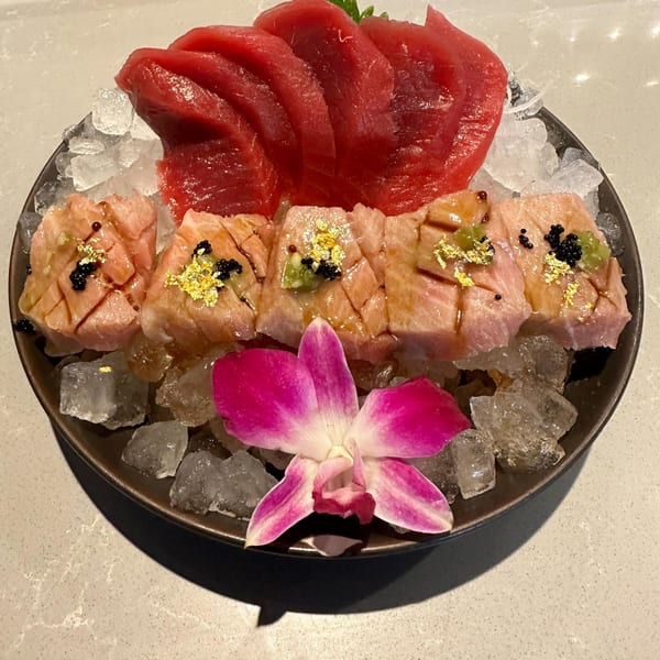 A platter of Top Sushi's tuna sashimi and seared tuna with caviar, gold flakes, and an orchid.